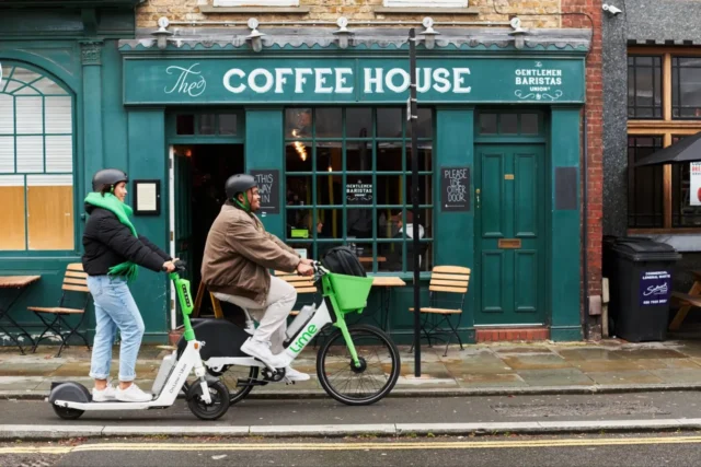 Lime riders with scooter and e-bike Two Lime riders using an electric scooter and e-bike outside a coffee shop