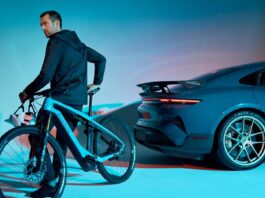 A rider on a Porsche eBike beside a Porsche Taycan Turbo GT